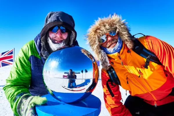 Posing with the silver ball atop the Ceremonial South Pole. Courtesy Carl Alvey, Antarctic Logistics & Expeditions