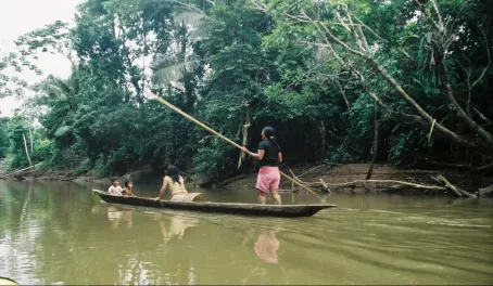 Locals travel down the Amazon in a dug out canoe