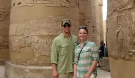 A couple standing amongst egyptian ruins.
