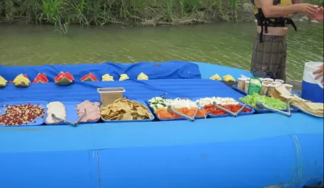 Guides serving lunch on an overturned raft, Pacuare River