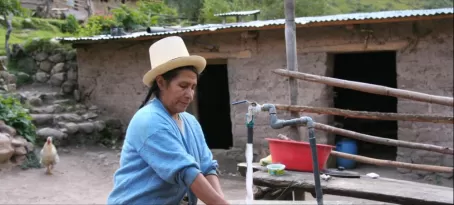 A Quechua woman washes dishes in her courtyard along the Inca Trail