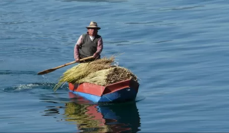 Paddling a cayuco, the traditional Lago Atitlan boat, with a load of reeds for weaving.