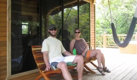 A happy couple relaxes on the porch at Hamanasi Resort