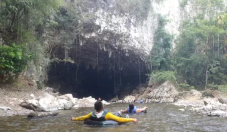 A guided tubing trip enters the mouth of the cave