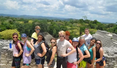 A student group stands atop the temple at Caracol ruins 