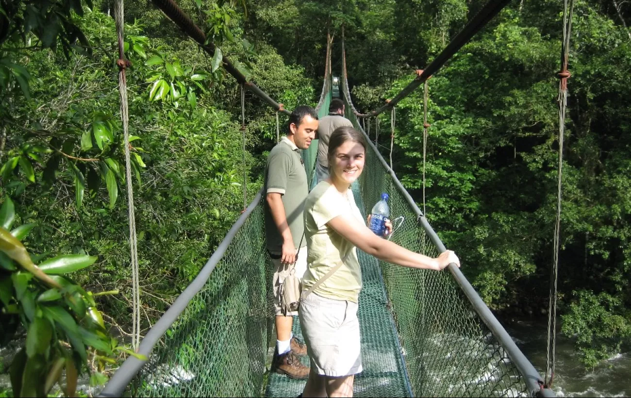 Crossing a suspension bridge while hiking Sarapiqui.