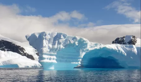 Beautiful blue icebergs emerge from the ocean.