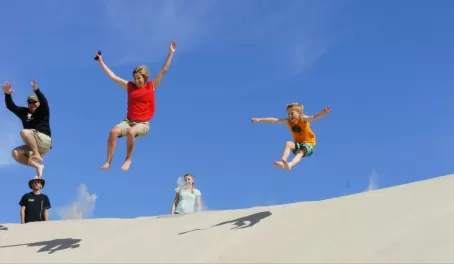 Jumping down a sand dune in Mexico