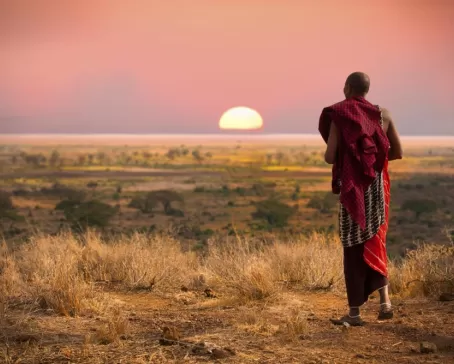 A Maasai warrior walks across the African bush