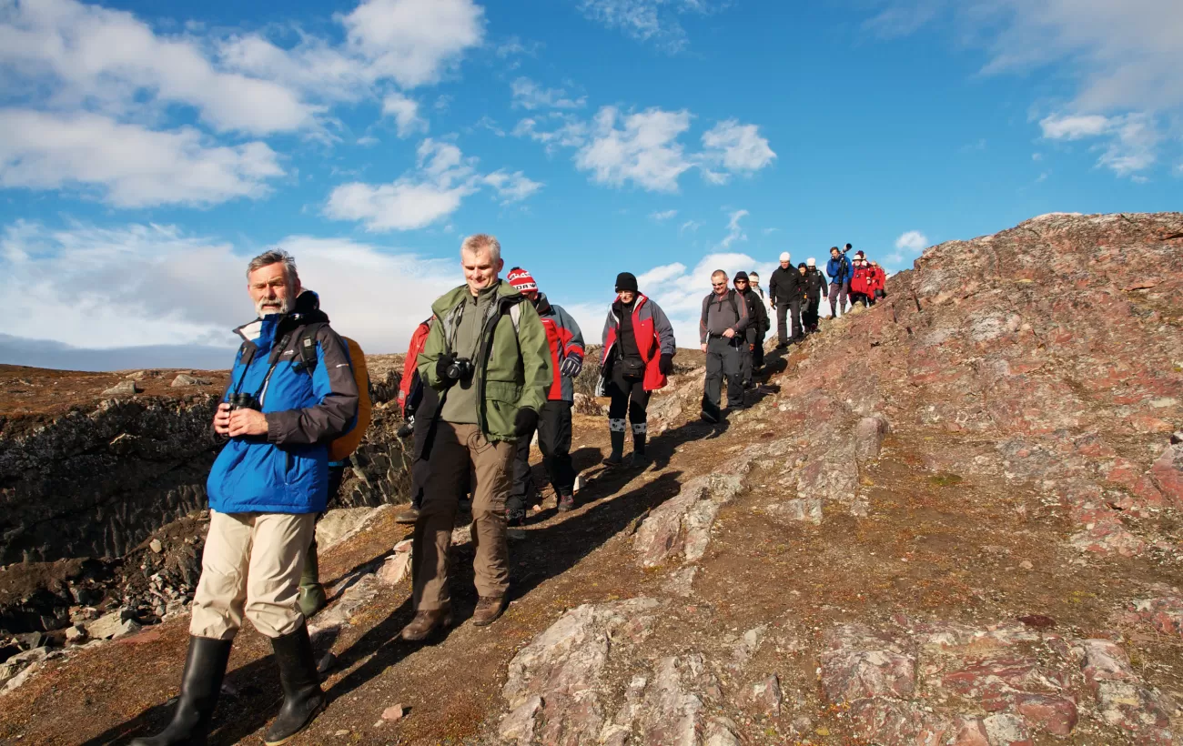 Travelers hiking through the Norwegian arctic.