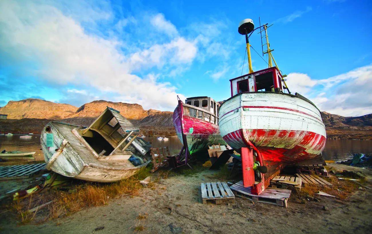 Abandoned boats resting on the shore.