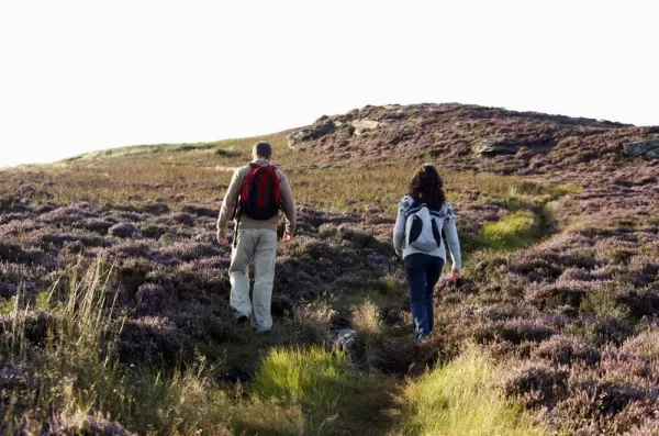 Hikers make their way up the rolling hills of the British Isles.