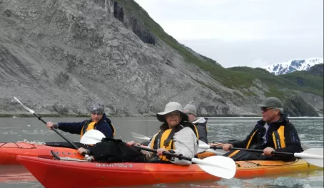 Travelers kayak through the cold Alaska waters
