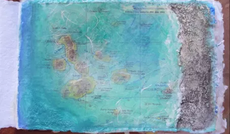 collage and painted map of Galapagos, with sand added for texture